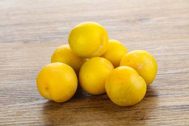 Arkaplanda olgun sarı erik yığını