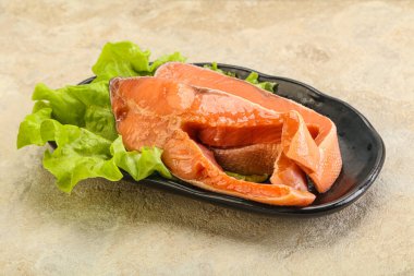 İki pembe somon balığı bifteği. Salata yaprağı.