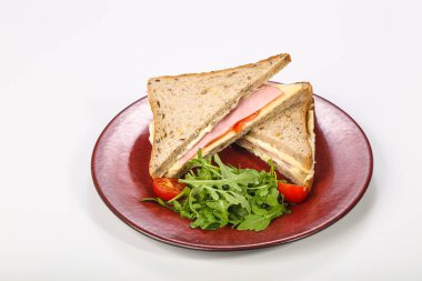 Jambonlu ve peynirli sandviç roka servis edildi.