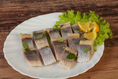 Dilimlenmiş limonla marine edilmiş ringa filetosu.