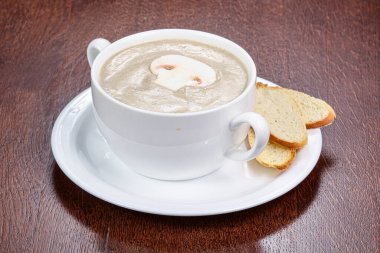 Dilimlenmiş ekmekle mantar kremalı çorba.