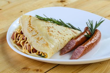 Dilimlenmiş sosis ve hardal soslu krep.