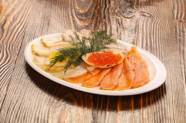 Dilimlenmiş balık, tabak aperatifiyle havyarı karıştırır.