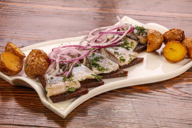 Ekmek, soğan ve patatesli ringa balığı.