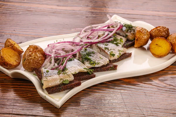 Ekmek, soğan ve patatesli ringa balığı.