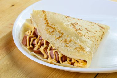 Dilimlenmiş sosis ve hardal soslu krep.