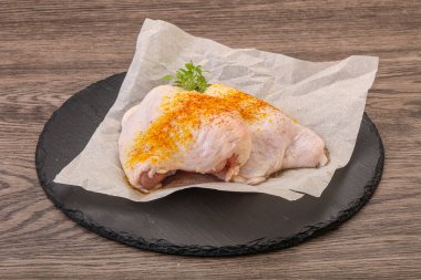 Kızartma için baharatlı çiğ tavuk budu.