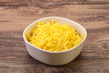 Yemek pişirmek için kasede dilimlenmiş sarı peynir.