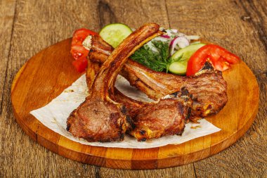 Izgara kuzu barbeküsü sebze ve soğan servis edilir.