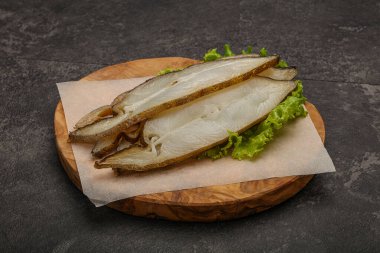Lezzetli füme halibut balığı aperatifi keser.