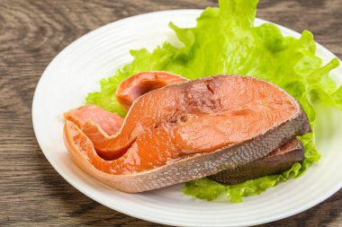 İki pembe somon balığı bifteği. Salata yaprağı.