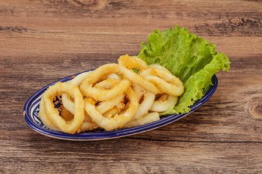 Kavrulmuş kalamar halkaları ve kasede salata.