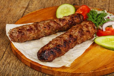 Biftek dilimlenmiş et shashlik sebze servis ediyordu.