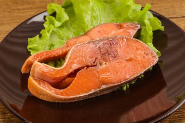 İki pembe somon balığı bifteği. Salata yaprağı.