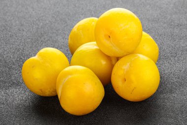 Arkaplanda olgun sarı erik yığını