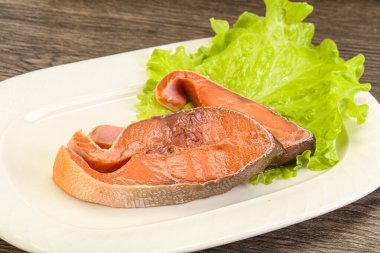 İki pembe somon balığı bifteği. Salata yaprağı.