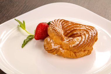 Çilek servis edilen süzme peynirli tatlı yüzük.