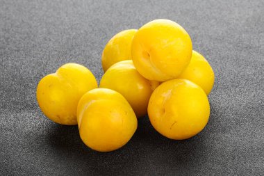 Arkaplanda olgun sarı erik yığını