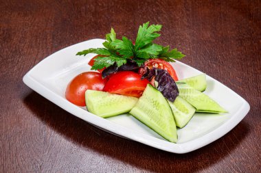 Dilimlenmiş sebzeli salata - domates, salatalık ve maydanoz