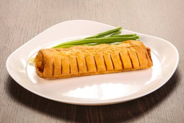 Hamurdaki lezzetli sosis yeşil soğan servis ediyordu.