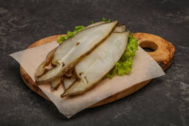 Lezzetli füme halibut balığı aperatifi keser.