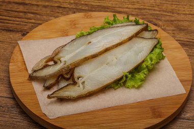 Lezzetli füme halibut balığı aperatifi keser.