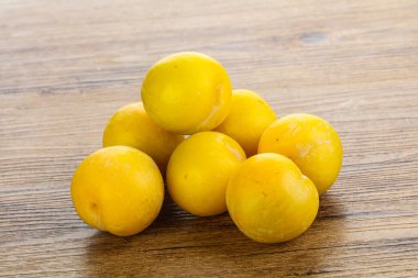 Arkaplanda olgun sarı erik yığını