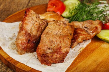 Izgara domuz eti, sebze ve soğan servis edildi.