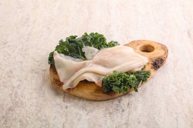 Ahşap tahtada pişirmek için çiğ mürekkep balığı