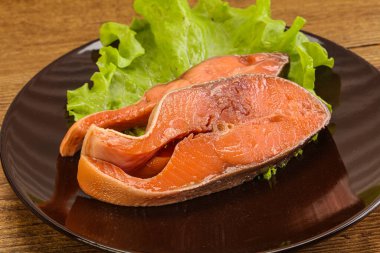 İki pembe somon balığı bifteği. Salata yaprağı.