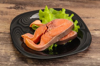 İki pembe somon balığı bifteği. Salata yaprağı.