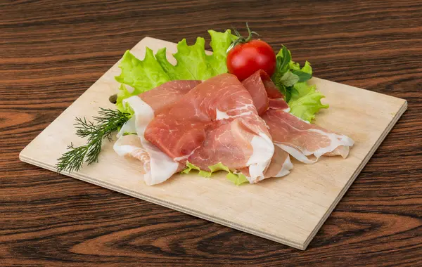 Prosciutto with salad leaves — Stock Photo, Image