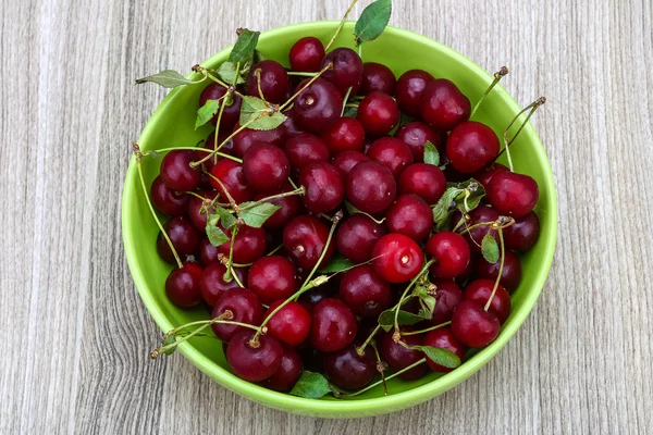 Körsbär i skålen med blad — Stockfoto