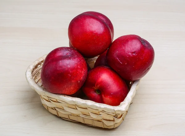 Ripe Nectarines in wooden plate — Stock Photo, Image