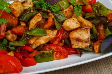 Kızarmış tavuğu sebzeyle karıştır