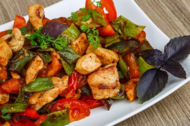 Kızarmış tavuğu sebzeyle karıştır