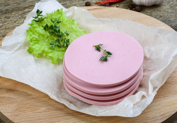 Sliced sausages with salad leaves — Stock Photo, Image