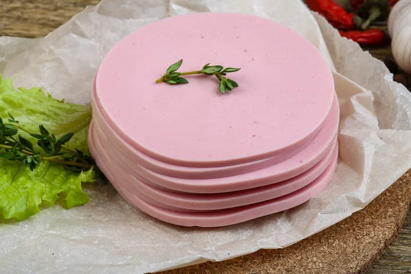 Salsichas fatiadas com folhas de salada — Fotografia de Stock