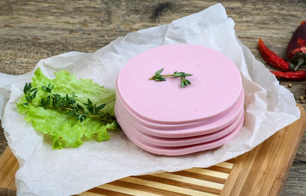 Sliced sausages with salad leaves — Stock Photo, Image