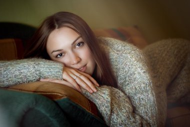 şehvetli ve seksi genç yetişkin esmer kadın kanepeye gri süveterli