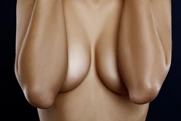 Обнажённое тело женщины, покрывающее её большую грудь — стоковое фото