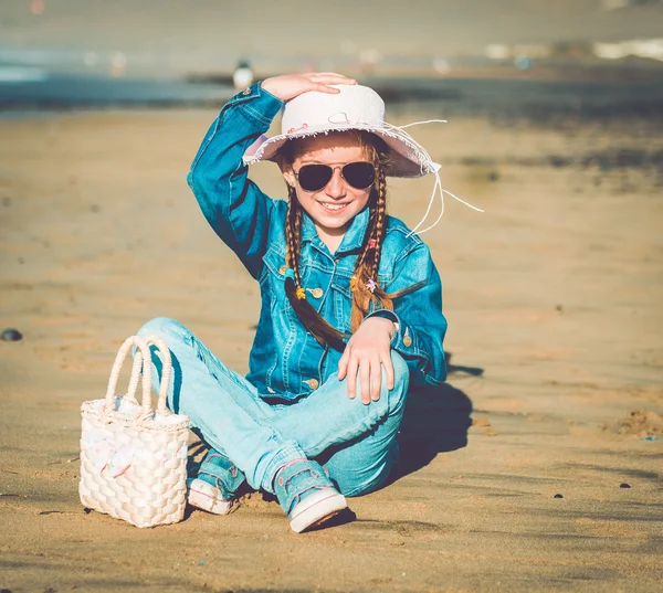 Liten flicka i hatt på stranden — Stockfoto