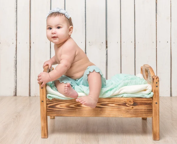 Niño pequeño y juguetón sentado en una cuna —  Fotos de Stock