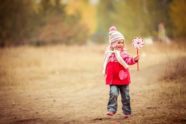 Little girl playing pinwheel toy — Stock Photo, Image