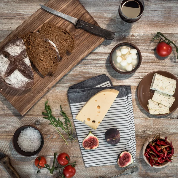 Bröd med ost och vindruvor på trä bakgrund — Stockfoto