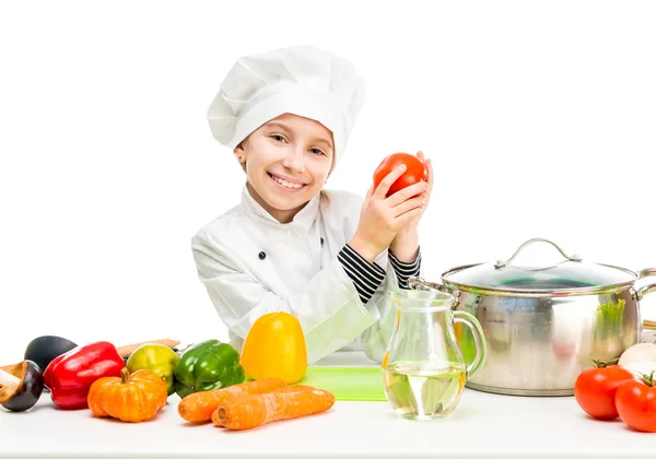Little girl-cook by table with vegetables — Stock Image Little girl-cook by table with vegetables Stock Image