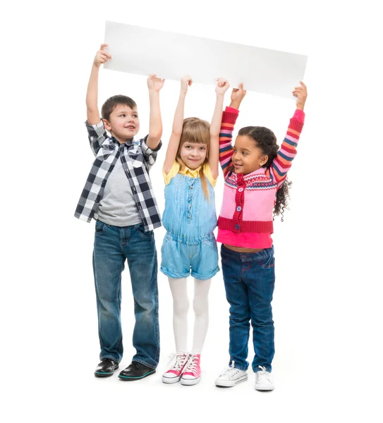 Boş kağıt sayfası tutarak açık ağızlı üç çocuk — Stok fotoğraf