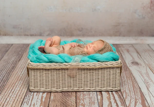 Söt newborn baby på turkos filt i barnsäng — Stockfoto