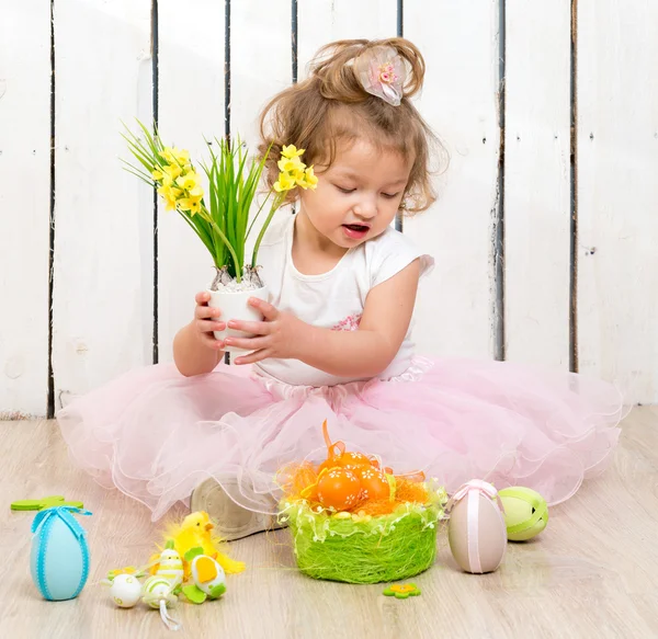 Nettes kleines Mädchen auf dem Boden sitzend mit Blumentopf in der Hand — Stockfoto