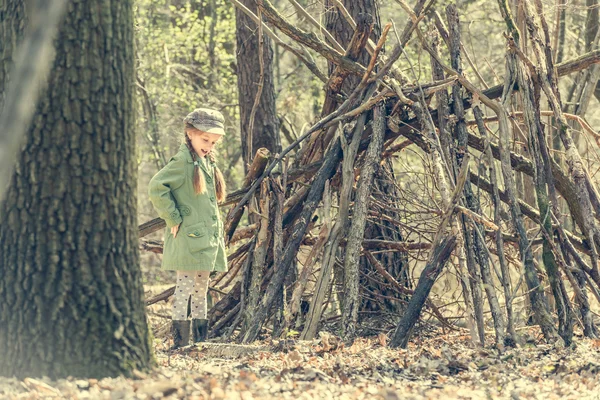 Ittle linda chica construye una cabaña en el bosque — Foto de Stock